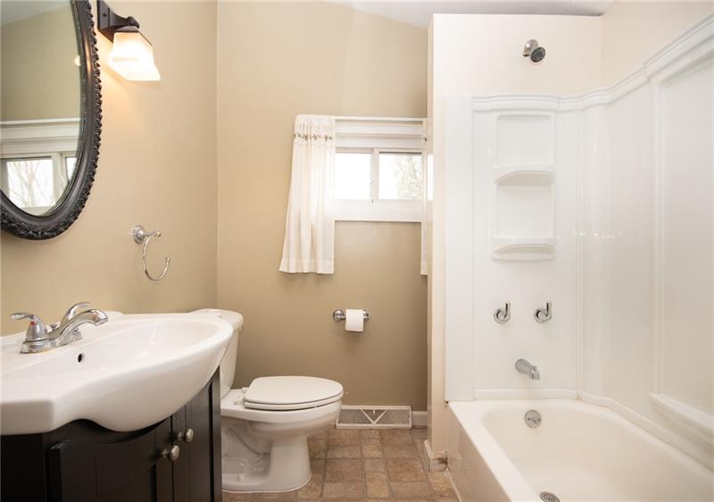 556 East Madison Street Rochester, PA 15074 - Photo 10 of 19 First Floor Main Bath features updated vanity, sink, commode and tub/shower surround. Nice neutral palette with a splash of Earth tones in the flooring.