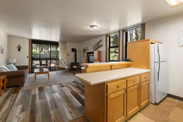 a kitchen with a refrigerator a stove and a dining table with wooden floor