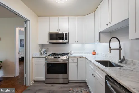a kitchen with stainless steel appliances granite countertop a sink a stove a microwave and cabinets
