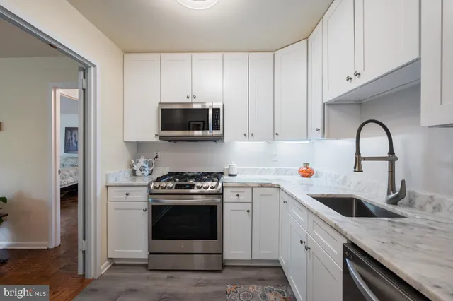 a kitchen with stainless steel appliances granite countertop a sink a stove a microwave and cabinets