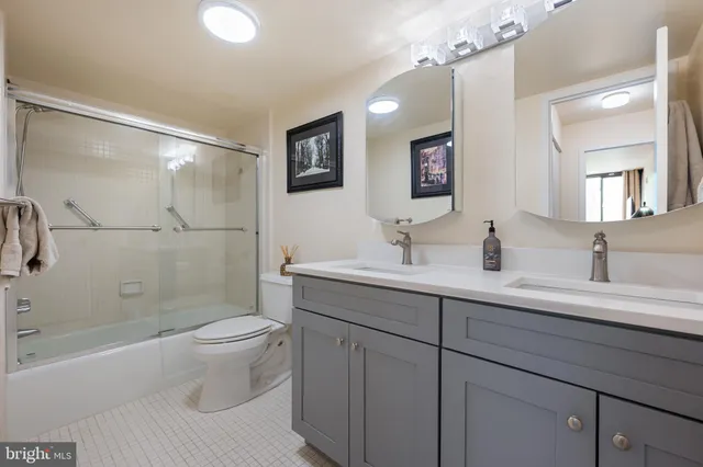 a bathroom with a double vanity sink toilet and shower