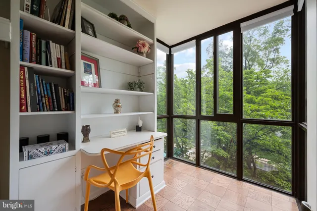 a view of a workspace with furniture and a book shelf
