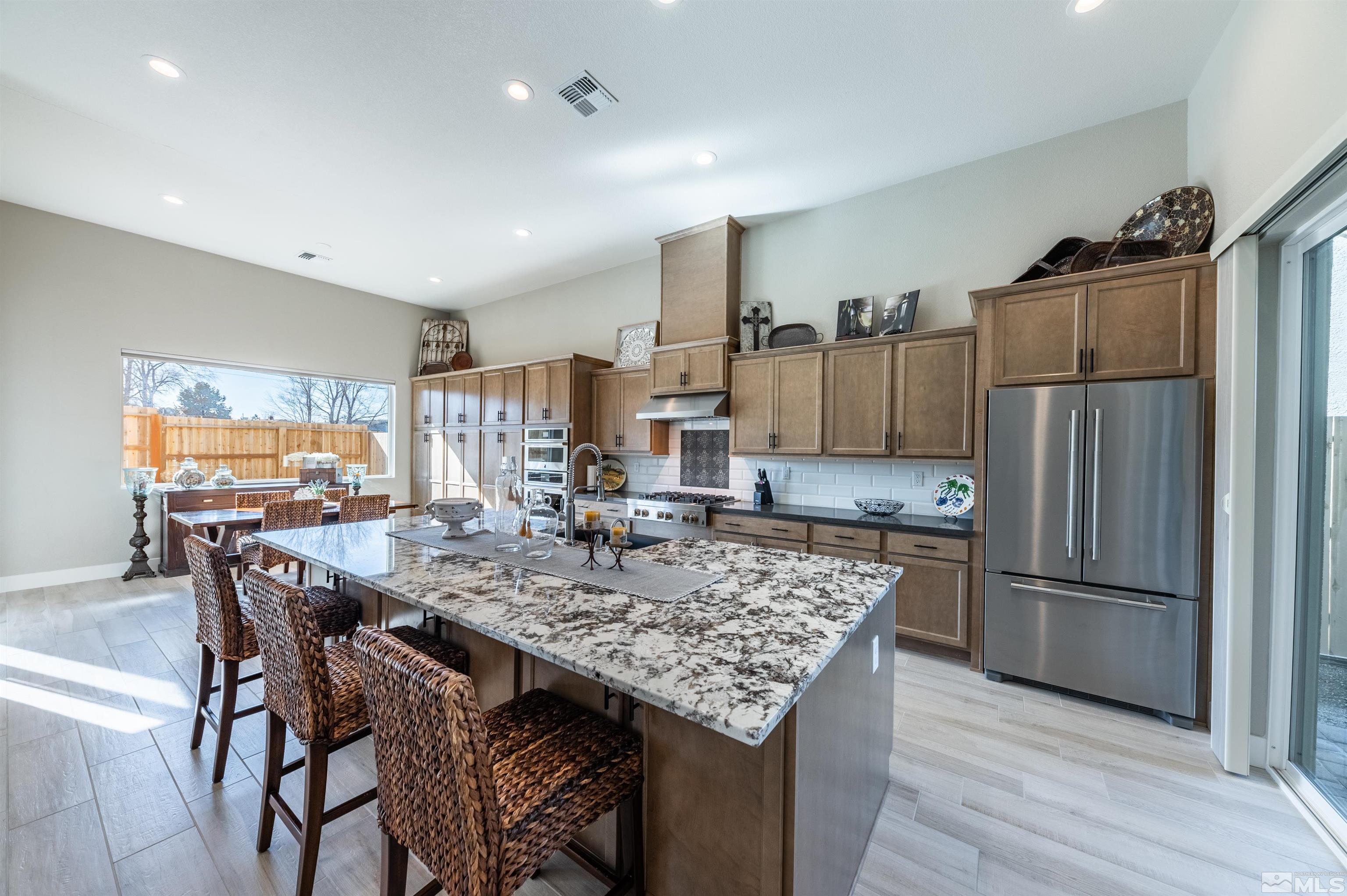 2962 Saddle Peak Drive Reno, NV 89521 - Photo 13 of 39 a kitchen with stainless steel appliances granite countertop sink refrigerator dining table and chairs
