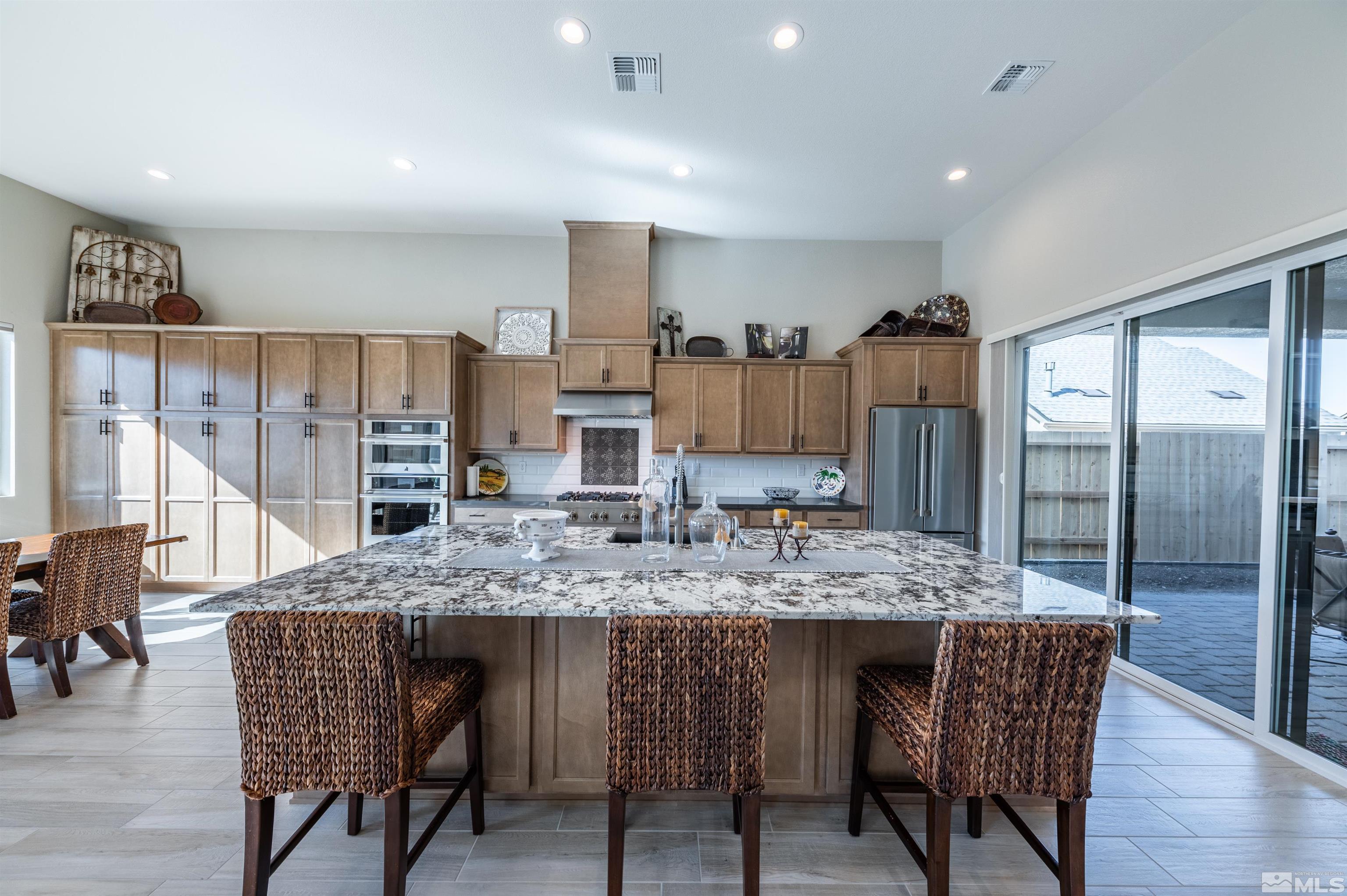 2962 Saddle Peak Drive Reno, NV 89521 - Photo 14 of 39 a kitchen with stainless steel appliances granite countertop table chairs sink refrigerator and stove