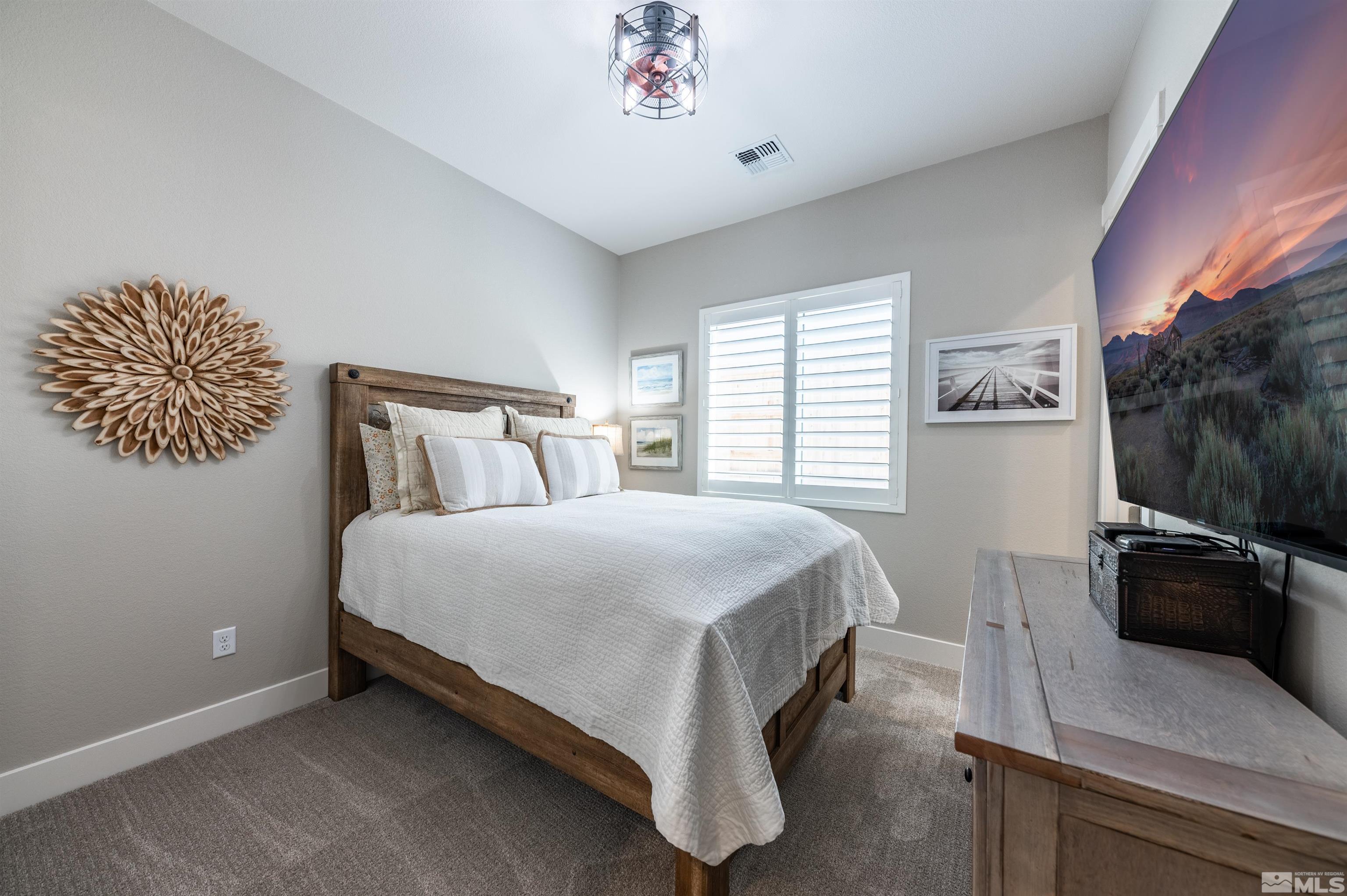 2962 Saddle Peak Drive Reno, NV 89521 - Photo 26 of 39 a bedroom with a bed and a potted plant on dresser