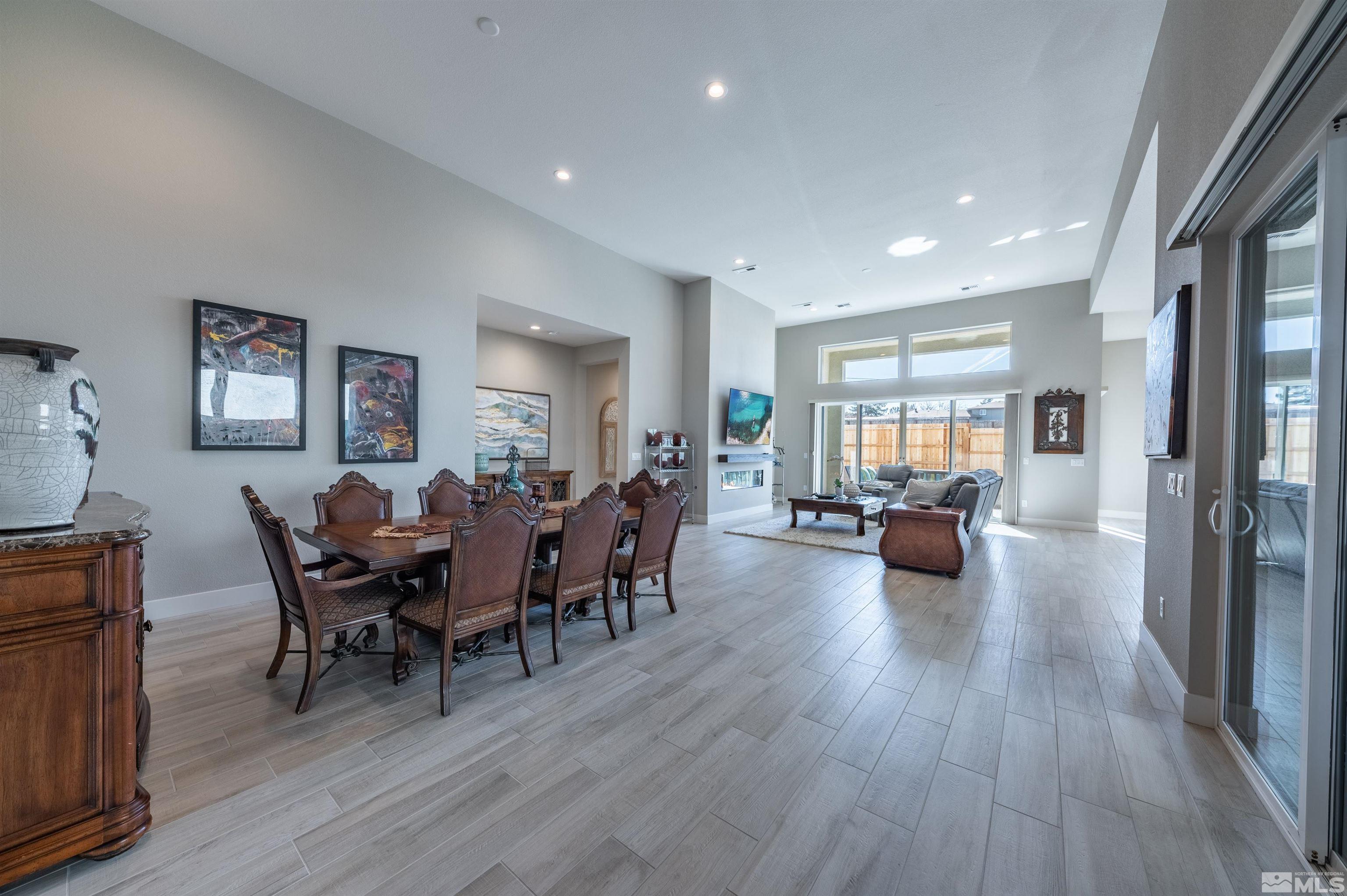 2962 Saddle Peak Drive Reno, NV 89521 - Photo 8 of 39 a view of a dining room and livingroom with furniture wooden floor a rug a flat screen tv a painting and a chandelier