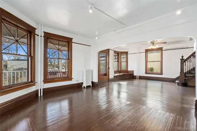 a view of empty room with wooden floor and windows