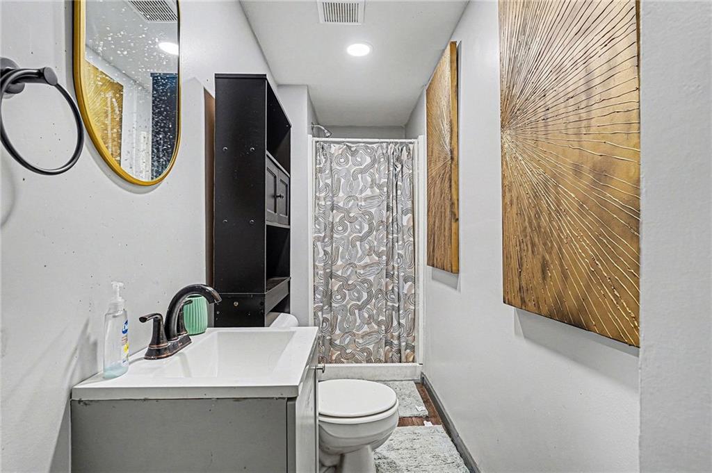 123 Brawner Street Griffin, GA 30223 - Photo 14 of 25 a bathroom with a sink a mirror and a toilet