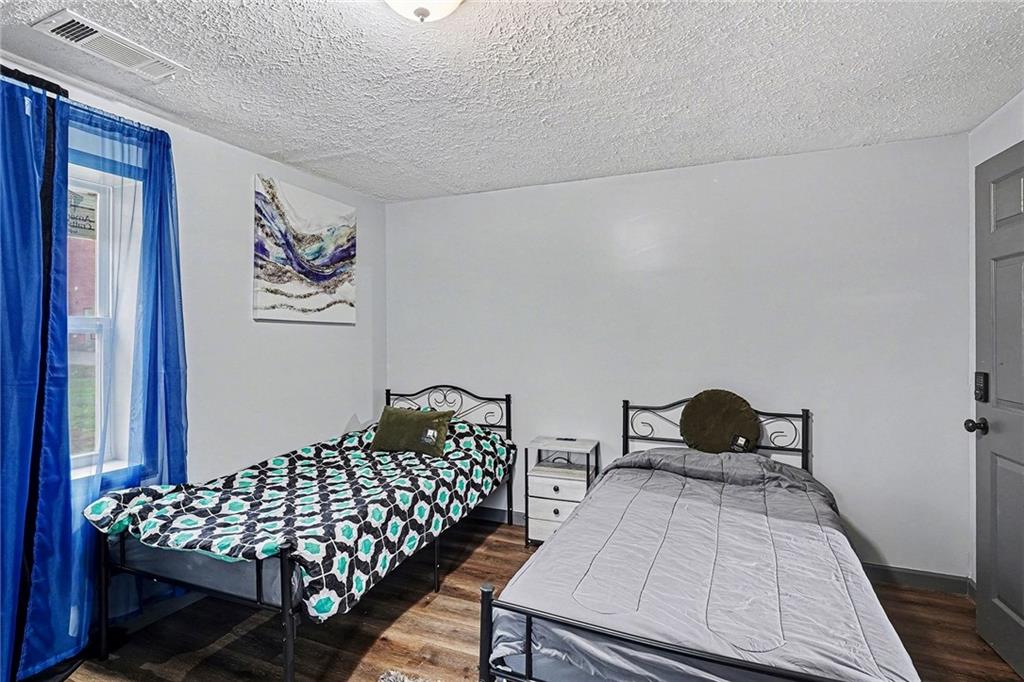 123 Brawner Street Griffin, GA 30223 - Photo 21 of 25 a bedroom with a bed and wooden floor