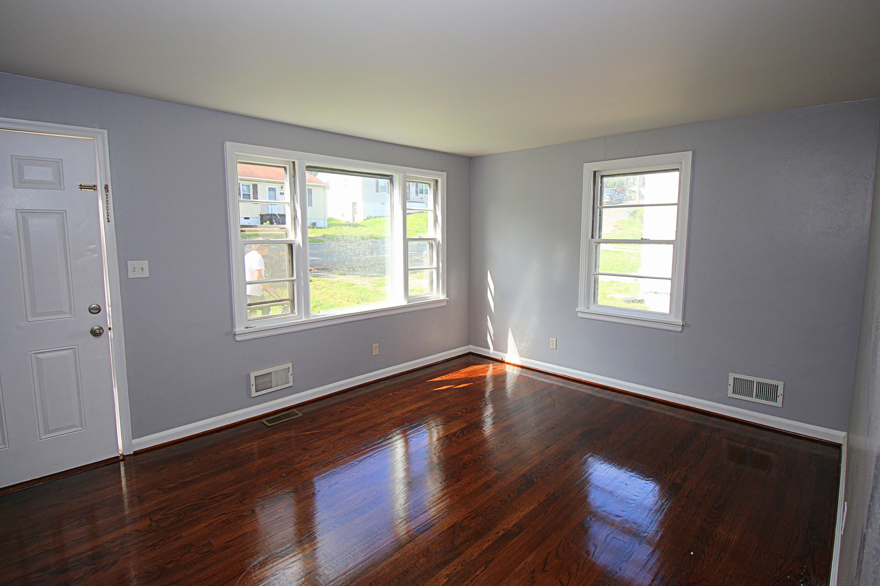 2205 Plantation Road Northeast Roanoke, VA 24012 - Photo 3 of 13 a view of an empty room with wooden floor and a window