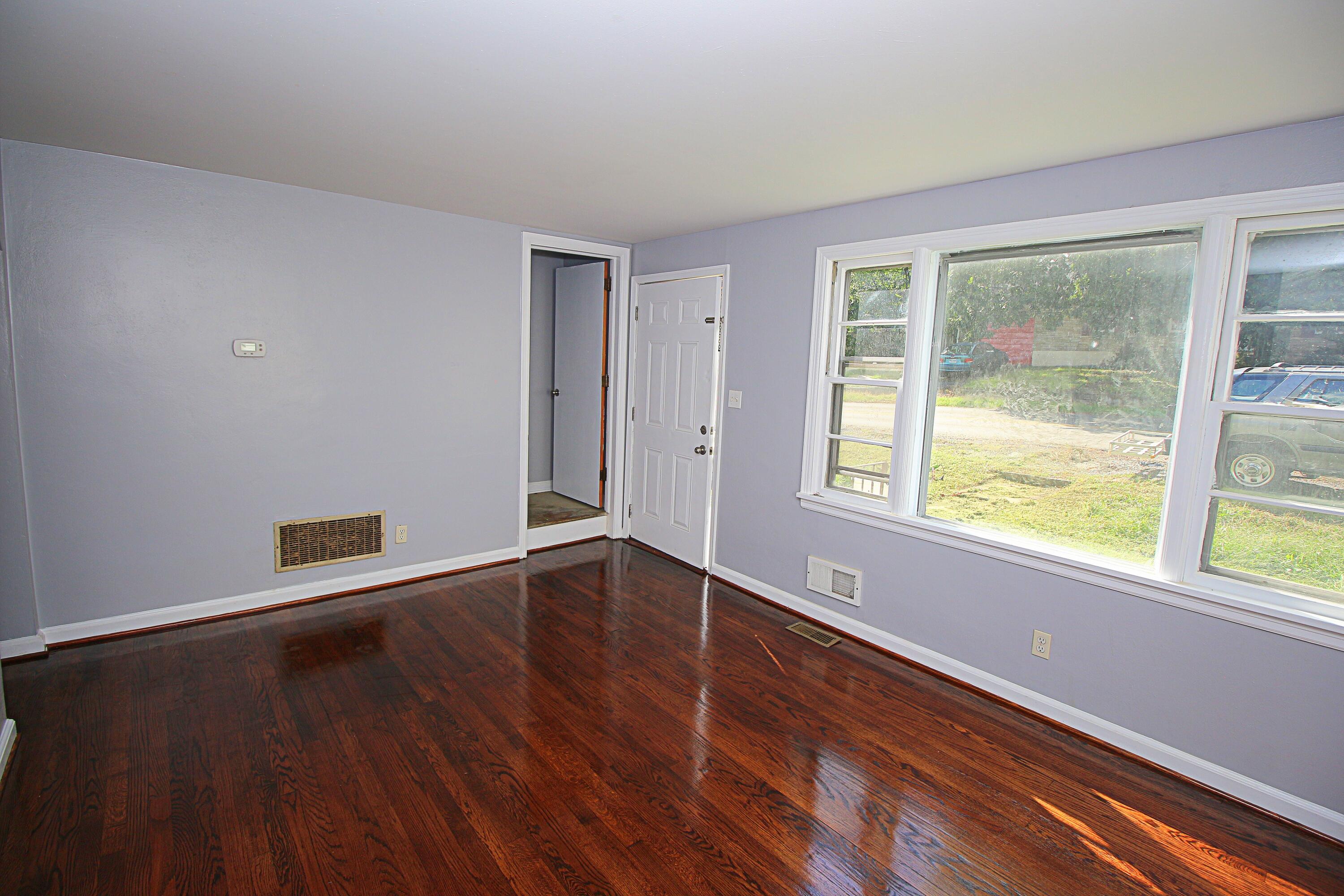 2205 Plantation Road Northeast Roanoke, VA 24012 - Photo 4 of 13 a view of an empty room with wooden floor and a window