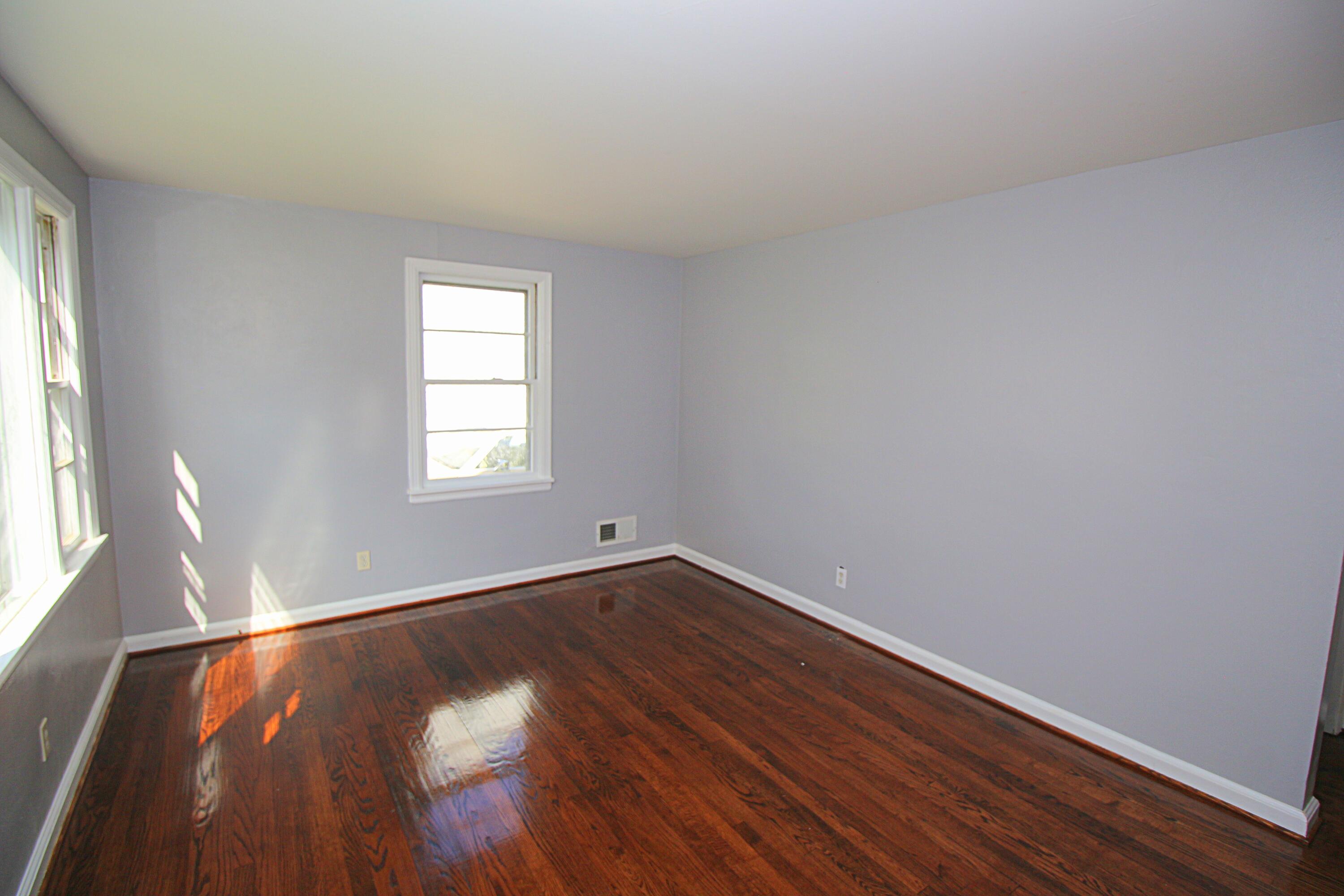 2205 Plantation Road Northeast Roanoke, VA 24012 - Photo 5 of 13 a view of an empty room with wooden floor and a window