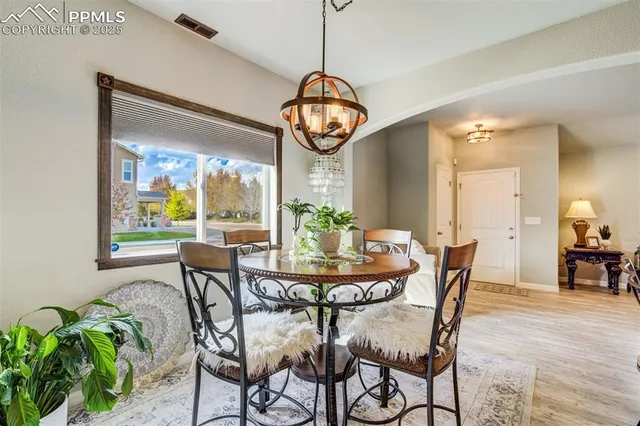 a dining room with furniture a kitchen and a chandelier