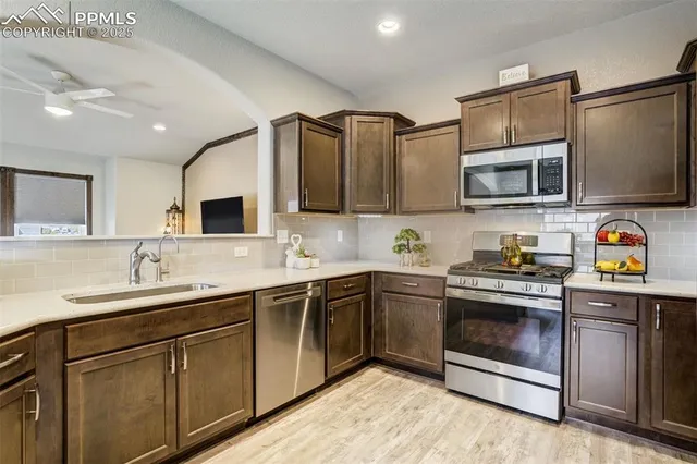 a kitchen with stainless steel appliances granite countertop a sink a stove top oven and cabinetry