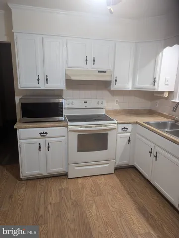 a kitchen with white cabinets and white appliances