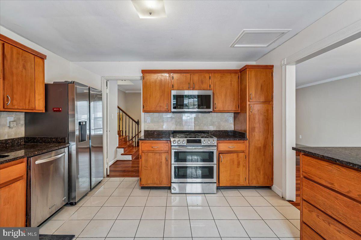 1521 Billman Lane Silver Spring, MD 20902 - Photo 11 of 33 a kitchen with stainless steel appliances granite countertop a stove a sink and a refrigerator