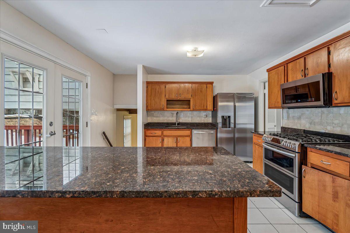 1521 Billman Lane Silver Spring, MD 20902 - Photo 10 of 33 a kitchen with stainless steel appliances granite countertop a stove a sink and a microwave