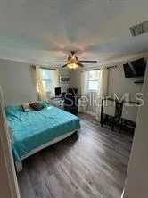 a bedroom with a bed a chandelier and a window