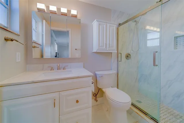 a bathroom with a sink a toilet and shower