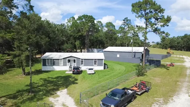 a view of a house with backyard sitting area and garden