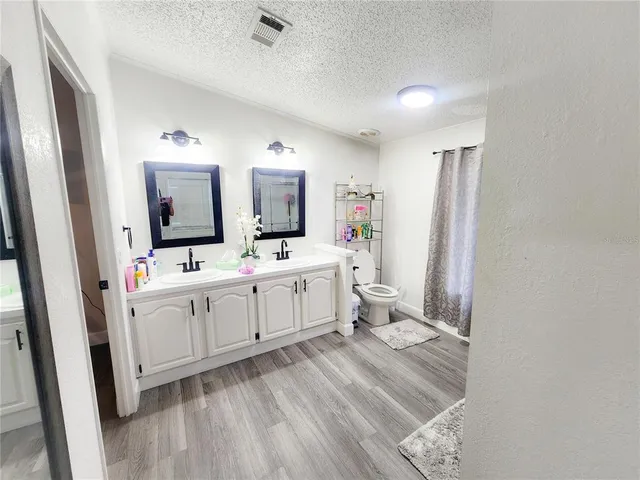 a green field with flowers and trees in the background