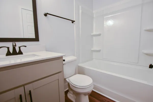 a bathroom with a sink toilet vanity and shower
