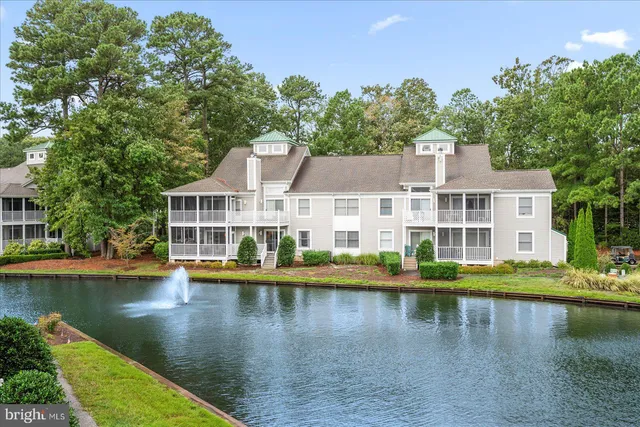 a view of a lake with building and trees in the background