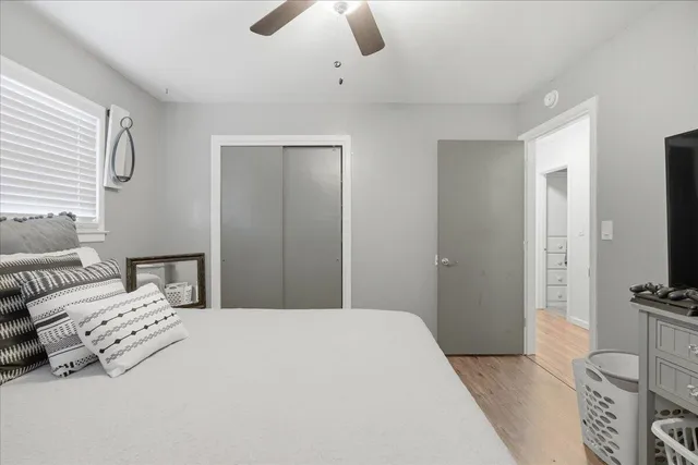 a bedroom with a bed a flat screen tv and dresser