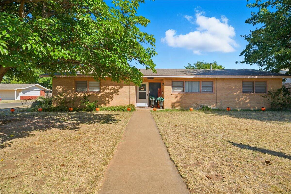 3816 44th Street Lubbock, TX 79413 - Photo 2 of 36 a front view of a house with a yard and garage