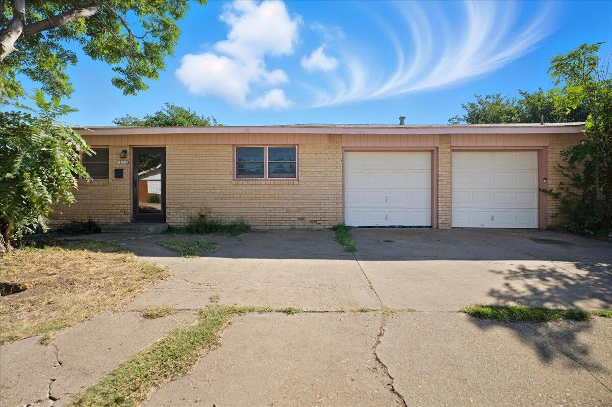 3816 44th Street Lubbock, TX 79413 - Photo 22 of 36 a front view of a house with a yard and garage
