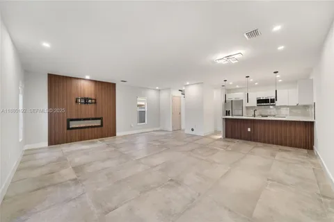 a view of an empty room with a kitchen