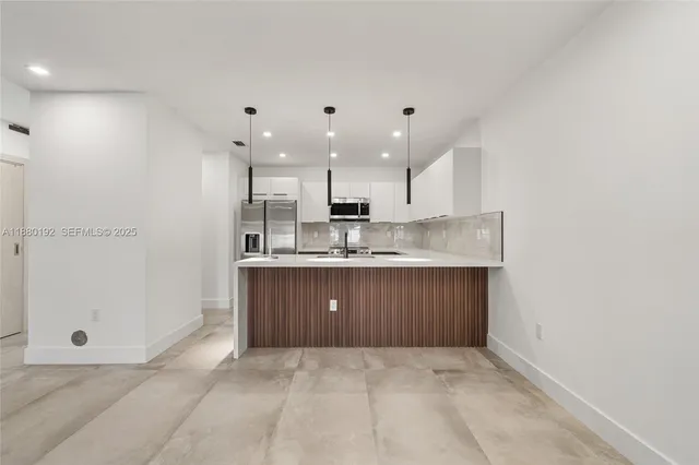 a large kitchen with a sink and cabinets