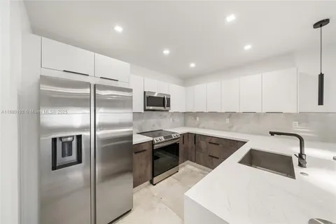a kitchen with a sink a refrigerator and cabinets