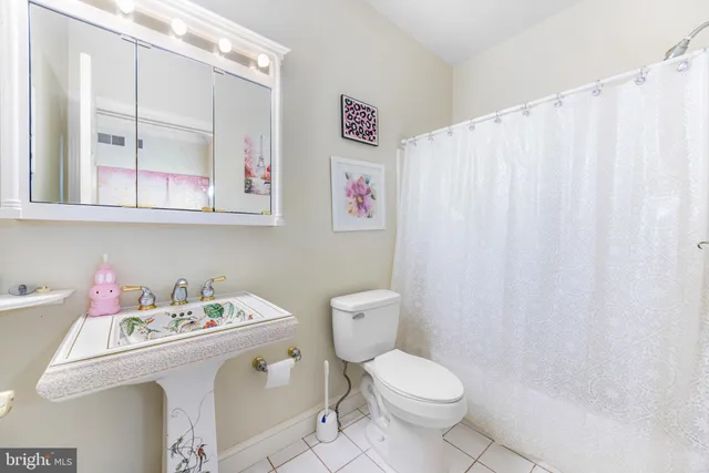 a bathroom with a sink a toilet and a shower curtain