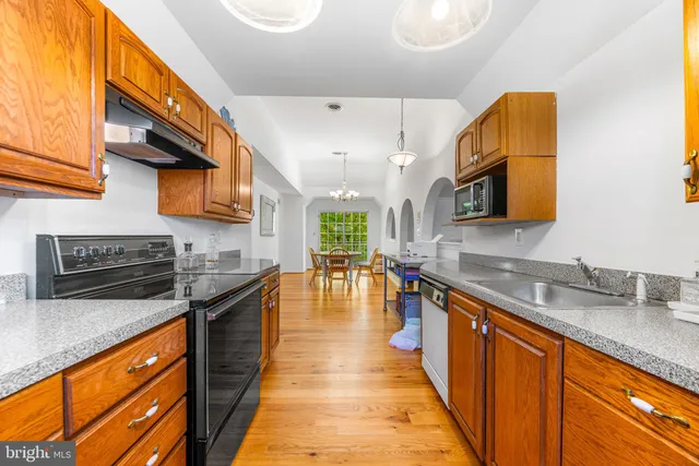 a large kitchen with stainless steel appliances granite countertop a sink and cabinets