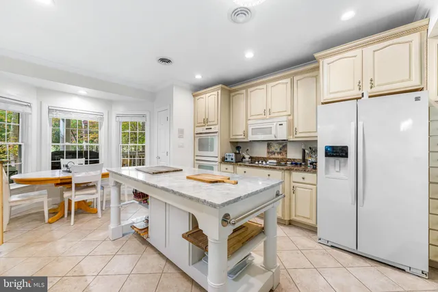 a kitchen with a stove a refrigerator and a stove top oven