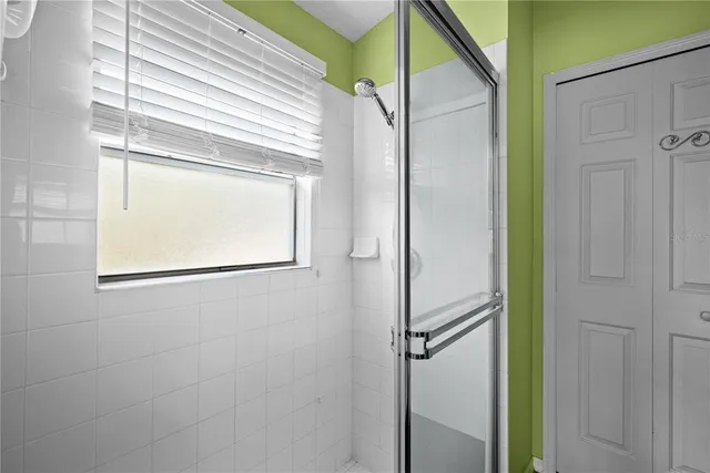 a bathroom with a glass shower door and a window