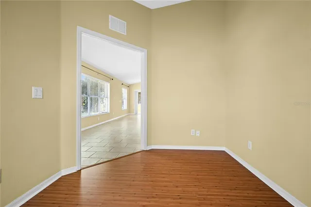 a view of empty room with wooden floor