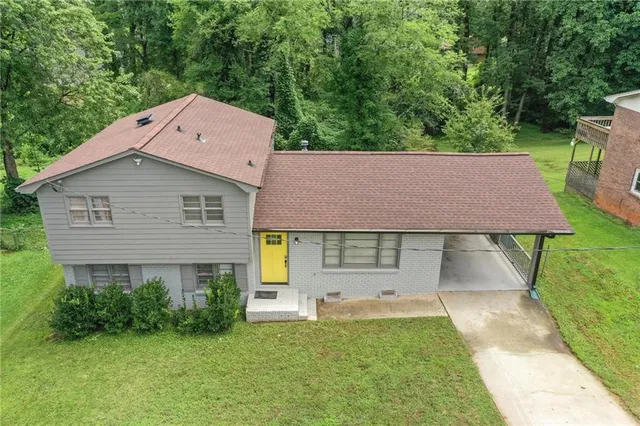 a aerial view of a house with a yard plants and large tree