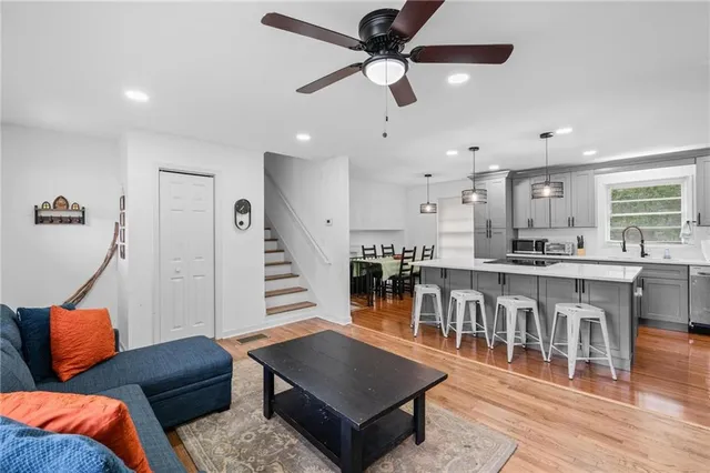 a living room with furniture a ceiling fan and a rug