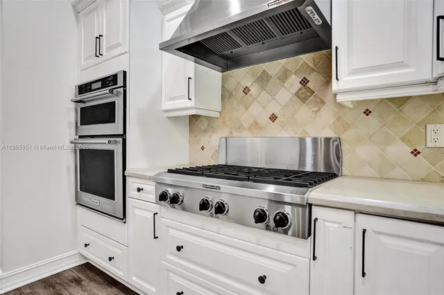 a spacious bathroom with a granite countertop sink a mirror and a bathtub