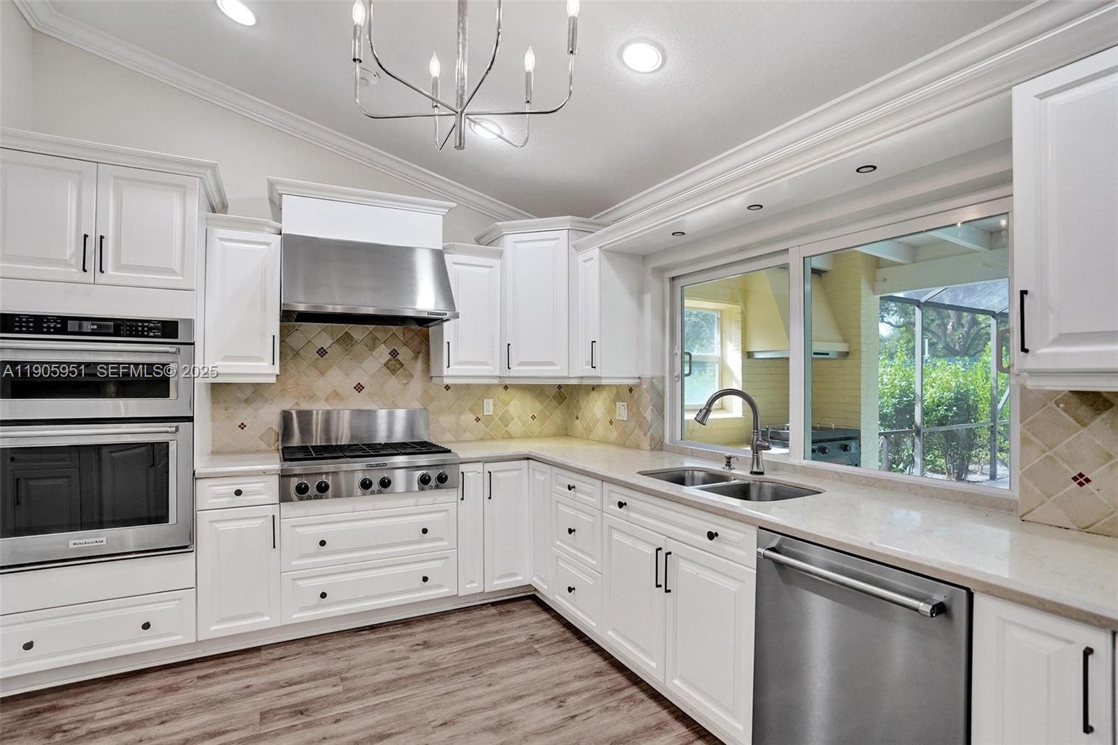 3801 Northwest 27th Avenue Boca Raton, FL 33434 - Photo 37 of 100 a kitchen with stainless steel appliances white cabinets a sink a stove a refrigerator and a microwave