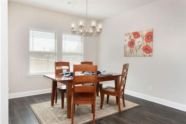 a view of a dining room with furniture a chandelier and wooden floor