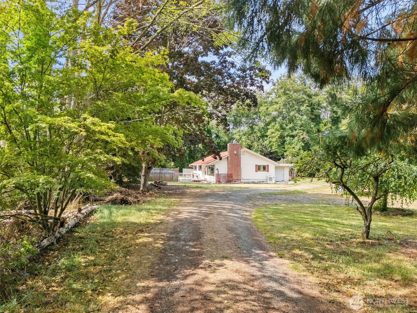 a white house with a big yard and large trees