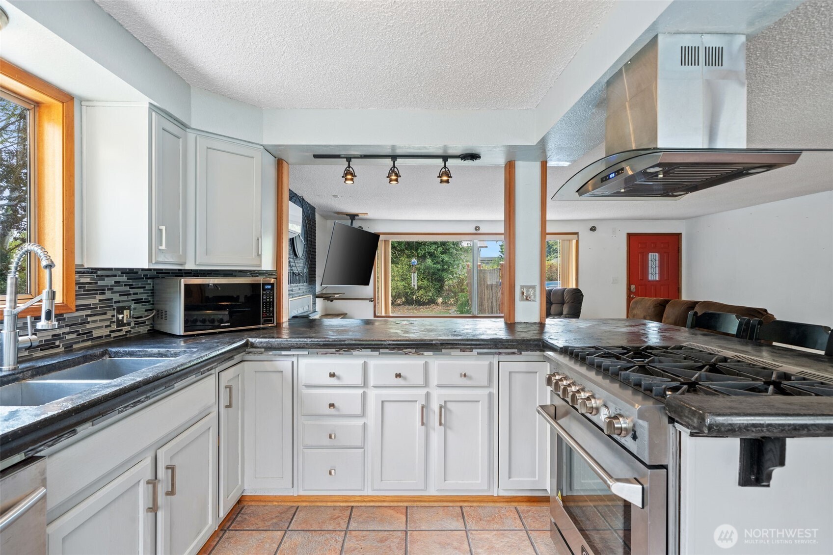 265 Cays Road Sequim, WA 98382 - Photo 14 of 40 a kitchen with granite countertop a sink appliances cabinets and a counter top space