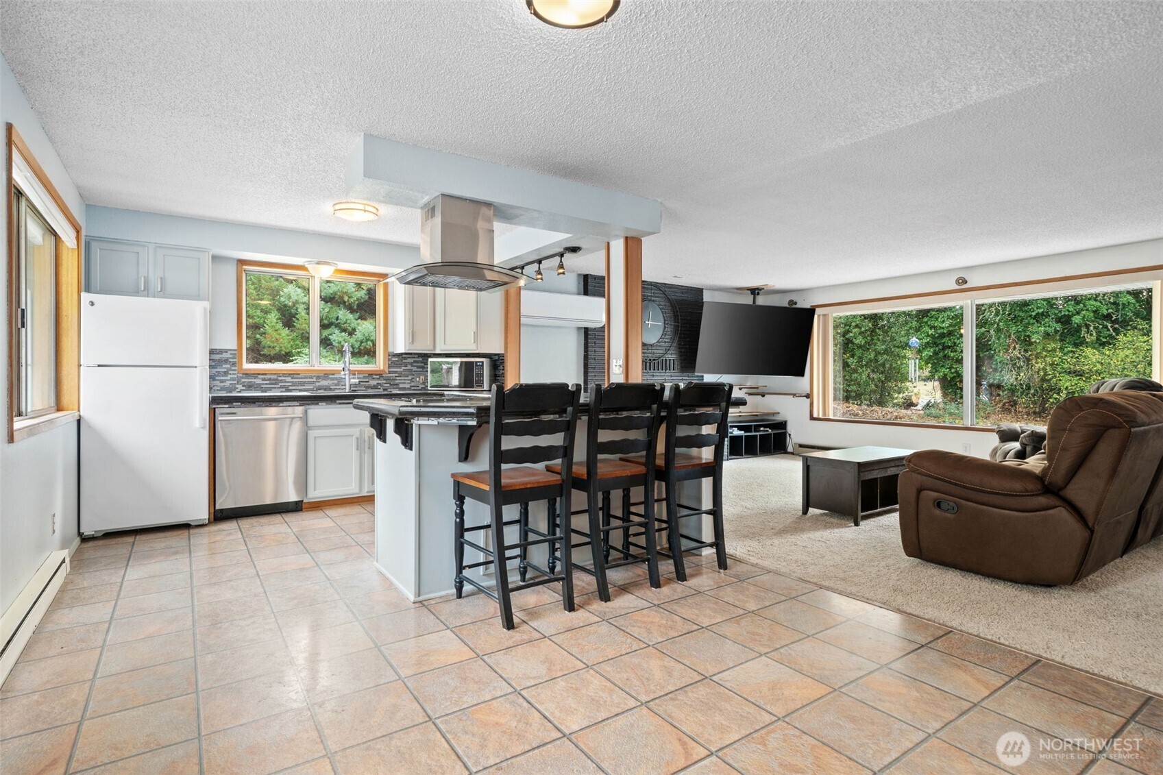 265 Cays Road Sequim, WA 98382 - Photo 10 of 40 a kitchen with stainless steel appliances granite countertop a stove a refrigerator a kitchen island a table and chairs