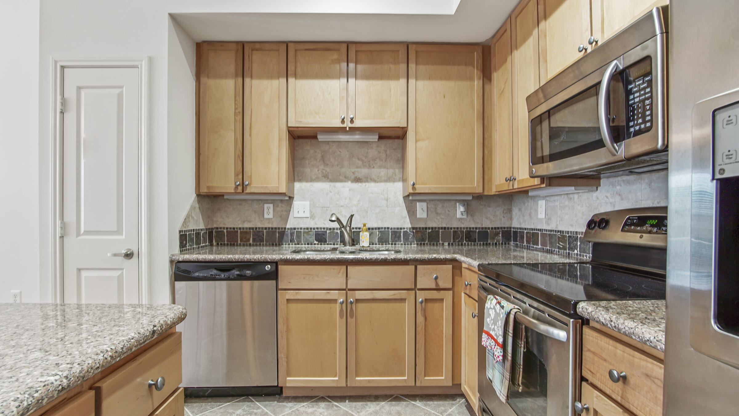 8700 Front Beach Road, Unit 5313 Panama City Beach, FL 32407 - Photo 11 of 38 a kitchen with stainless steel appliances granite countertop a stove a sink and a microwave