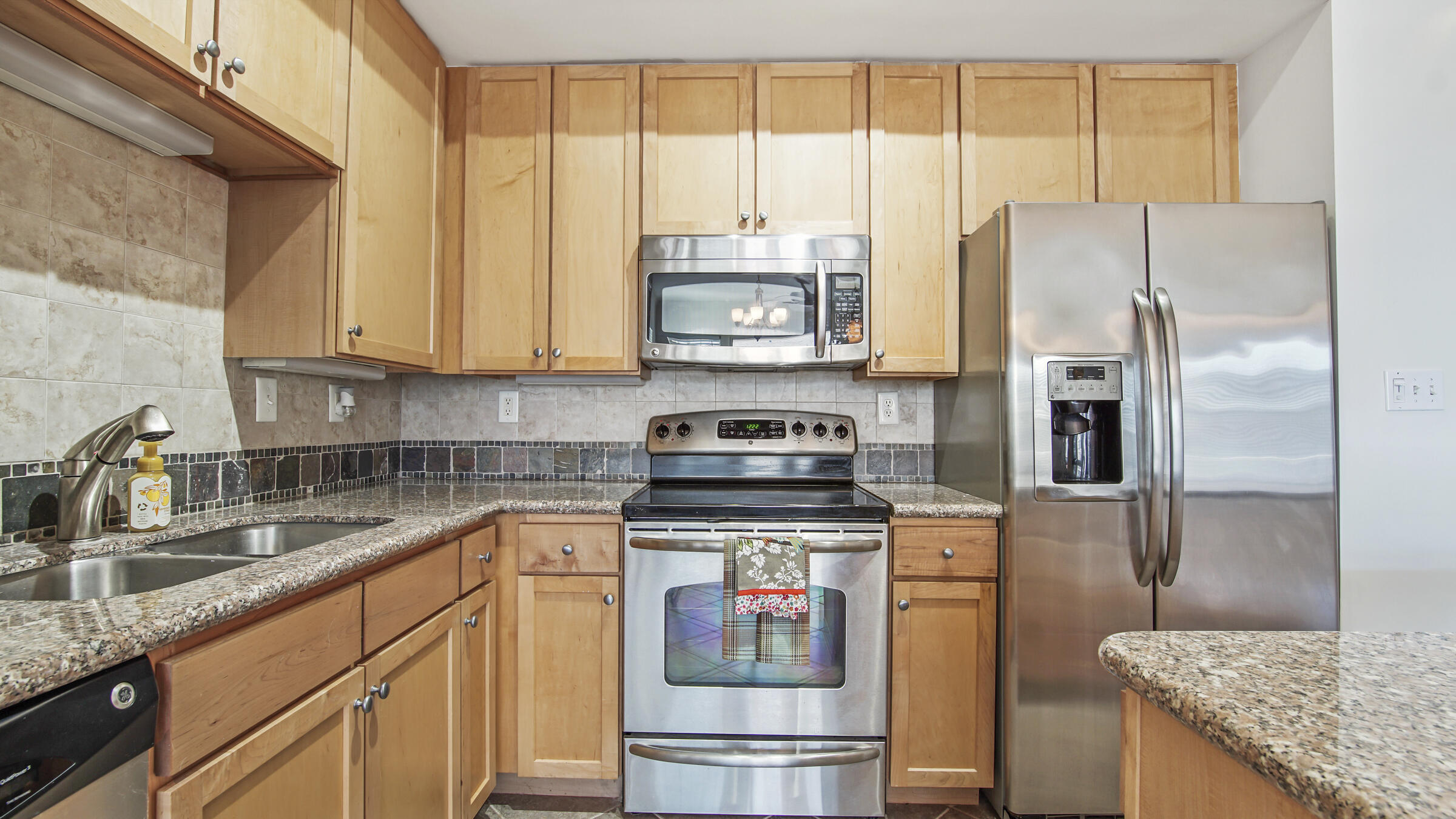 8700 Front Beach Road, Unit 5313 Panama City Beach, FL 32407 - Photo 13 of 38 a kitchen with granite countertop a refrigerator and a sink
