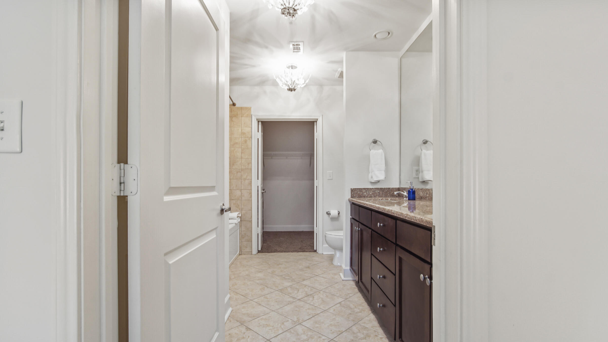 8700 Front Beach Road, Unit 5313 Panama City Beach, FL 32407 - Photo 18 of 38 a bathroom with a granite countertop double vanity and a mirror