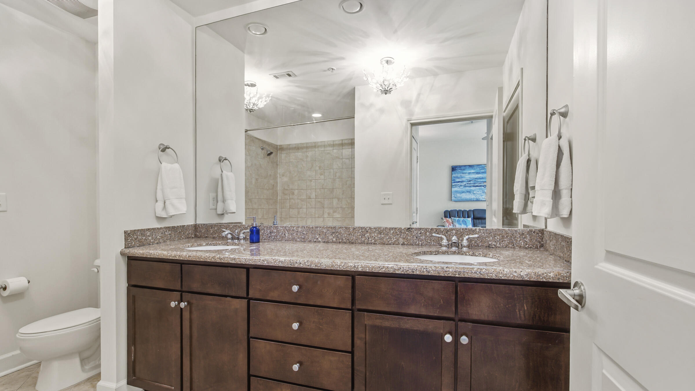 8700 Front Beach Road, Unit 5313 Panama City Beach, FL 32407 - Photo 21 of 38 a bathroom with a granite countertop sink vanity mirror and toilet
